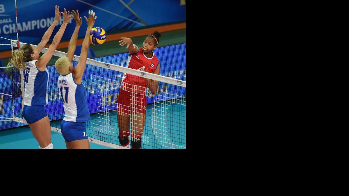 
La cubana Melissa Vargas remata contra el bloqueo de Puerto Rico en el Mundial de Roma.


