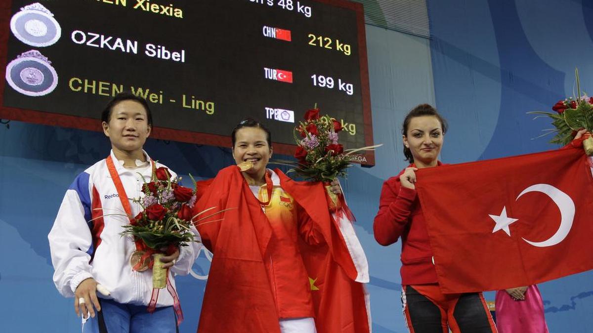 La turca Sibel Ozkan (der.), plata; la china Chen Xiexia (centro), oro; y la taiwanesa Chen Wei-Ling, bronce, en la premiación de la prueba de 48kg en levantamiento de pesas en los Juegos Olímpicos de Beijing 2008, el 9 de agosto.
