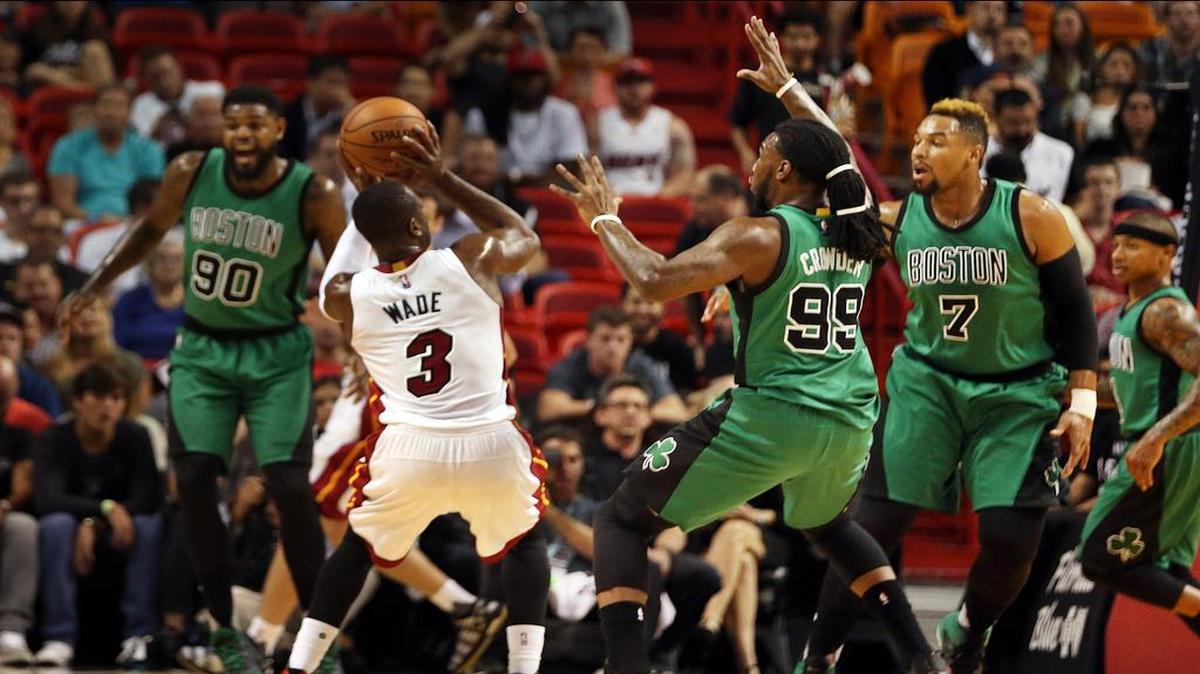 Dwyane Wade (izq.) trata de tirar al aro ante la marca de los jugadores de Boston Jae Crowder (#99) y Jared Sullinger (#7), el lunes en Miami.