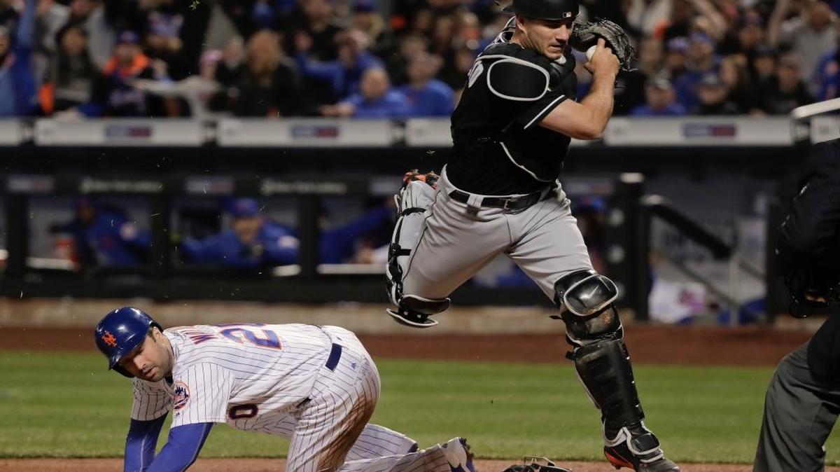 J.T. REALMUTO salta por encima de Neil Walker tras ponerlo out en la goma el 9 de abril.