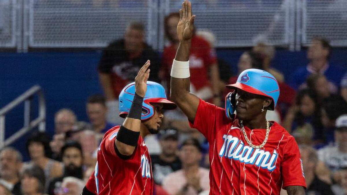 Jazz Chisholm Jr. (der.) y Luis Arráez celebran tras anotar carreras en un partido entre los Marlins y los Cachorros, celebrado el 29 de abril de 2023 en Miami.