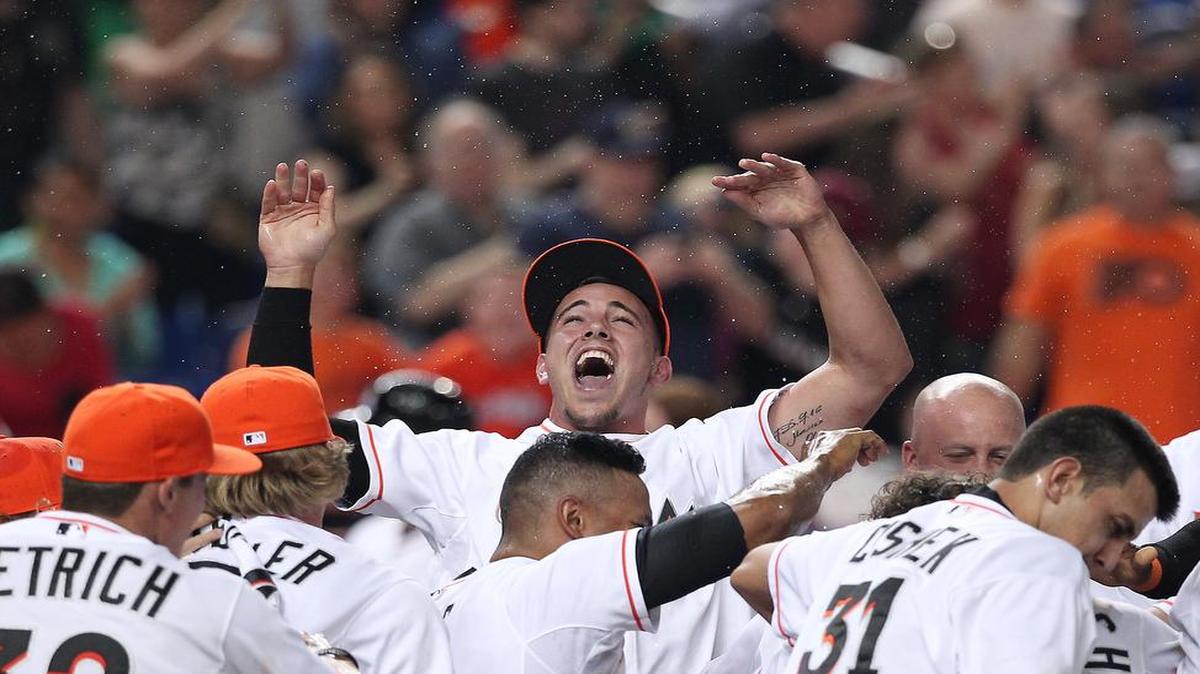 José Fernández celebra con sus compñeros de equipo después de un jonrón del jardinero Giancarlo Stanton que decretó la victoria de los Marlins en el noveno episodio ante los Marineros de Seattle, en un partido interligas, el 18 de abril del 2014, en Miami.