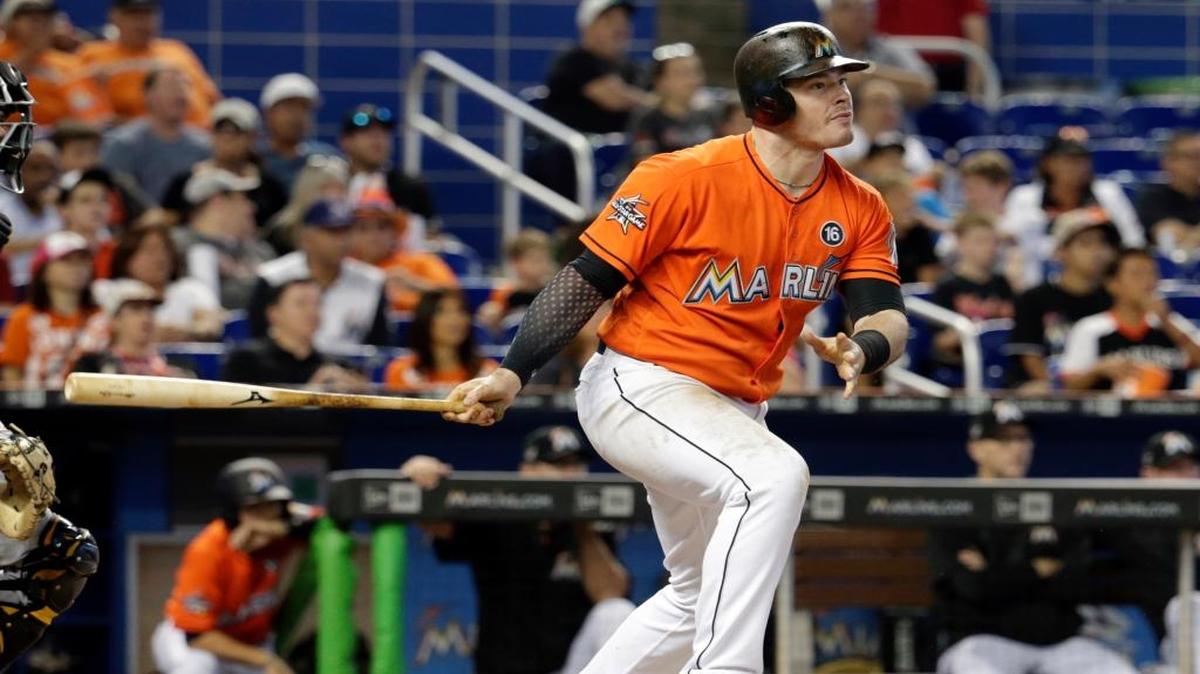 Justin Bour, de los Marlins, mira la pelota luego de conectar un sencillo que impulsó a Dee Gordon y Giancarlo, en el quinto inning contra los Piratas, el domingo 30 de abril del 2017, en Miami.
