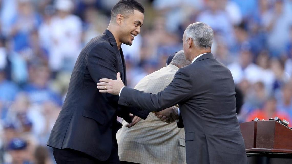 GIANCARLO STANTON recibe el premio Hank Aaron de manos del comisionado Rob Manfred.