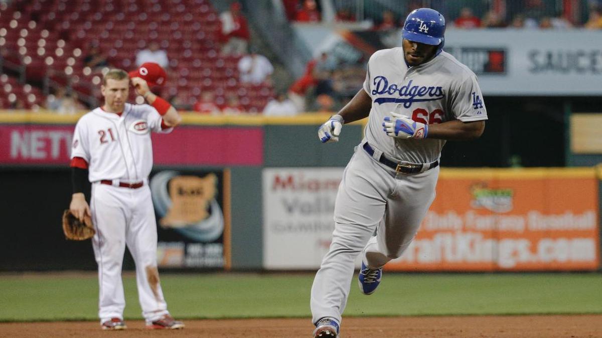 El jardinero cubano de los Dodgers de Los Ángeles Yasiel Puig dobla por tercera base tras su jonrón de dos carreras ante la mirada del antesalista de los Rojos, Todd Frazier, en la cuarta entrada del juego celebrado el 26 de agosto de 2015, en Cincinnati. 
