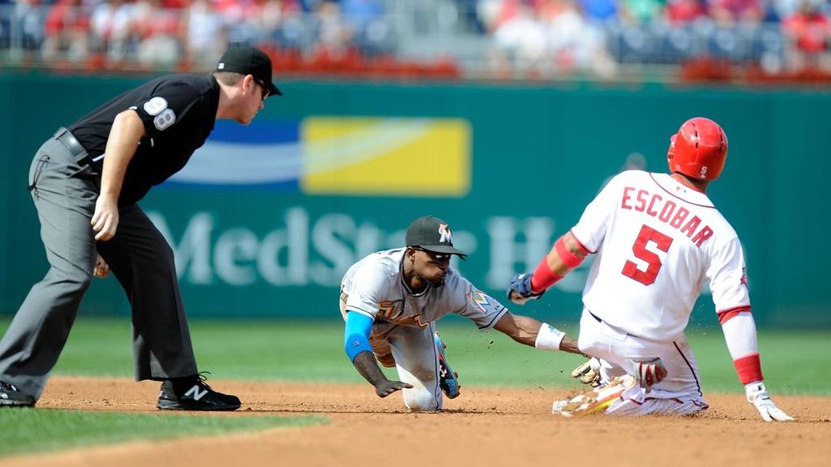 
YUNEL ESCOBAR se desliza en segunda tras conectar un doblete remolcador de carrera mientras que Dee Gordon trata de sacarlo out. Los Nacionales derrotaron a los Marlins.
