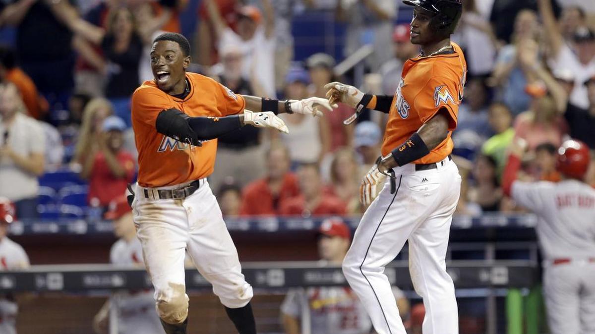 ADEINY HECHAVARRIA (d) es saludado por Dee Gordon tras anotar una carrera el 31 de julio del 2016.