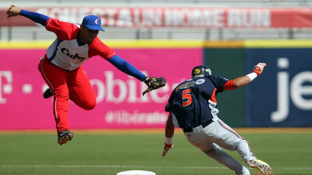 
El torpedero cubano Luis Alberto Valdéz (izq.) trata de poner out en segunda base al corredor de Venezuela Orlando Arcia, en un partido de la Serie del caribe, celebrado el 5 de febrero del 2015, en Puerto Rico.
