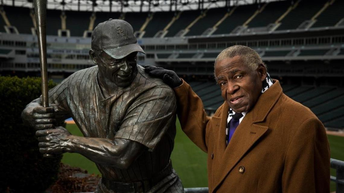 Orestes ‘Minnie’ Miñoso posa al lado de su estatua en el U.S. Cellular Field de Chicago el 14 de noviembre del 2017.