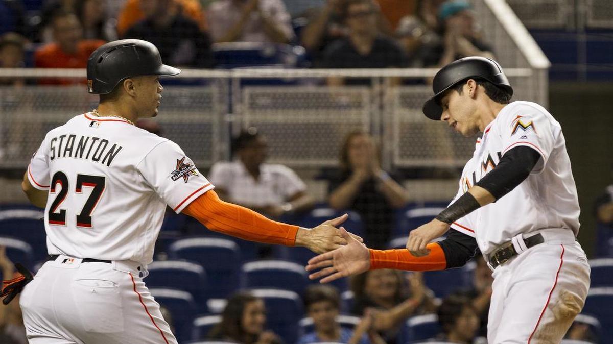 Giancarlo Stanton (izq.) y Christian Yelich celebran tras anotar por los Marlins en el primer inning en el partido contra los Mets, celebrado el 27 de junio del 2017 en Miami.