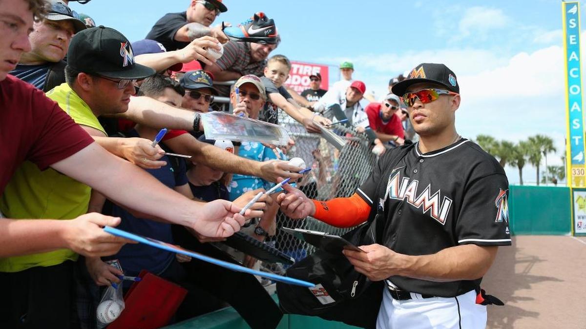 GIANCARLO STANTON firma pelotas durante un choque de primavera contra los Nacionales el 4 de marzo en Jupiter, Florida.