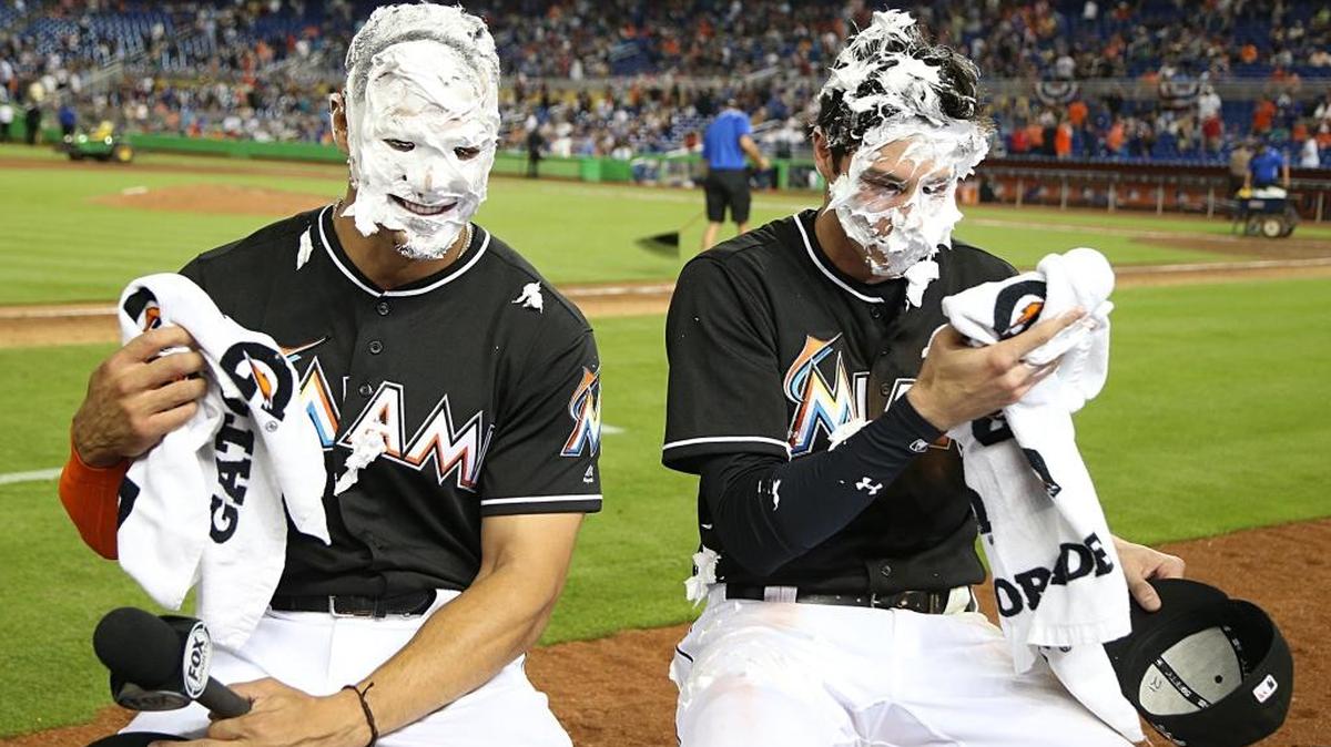 GIANCARLO STANTON y Christian Yelich (d) se limpian la crema de afeitar con la cual los peces celebran una jornada de triunfos el 15 de abril.
