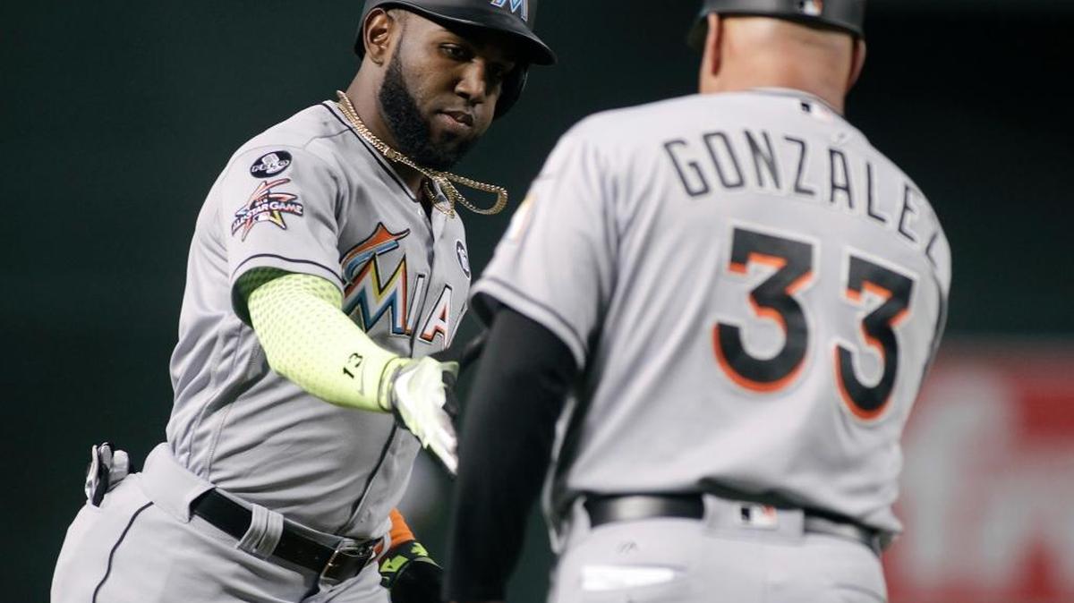 FREDI GONZALEZ, coach de tercera, felicita a Marcell Ozuna tras pegar un cuadrangular en la primera entrada contra Arizona el 22 de septiembre.