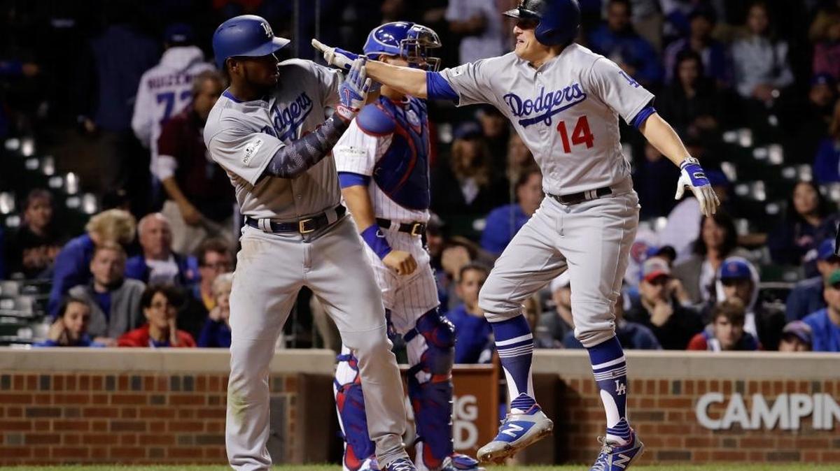 El cubano Yasiel Puig y el boricua Enrique Hernández (14), de los Dodgers, celebran luego de que Hernández bateara un jonrón contra los Cachorroen el Wrigley Field en Chicago el jueves 19 de octubre.