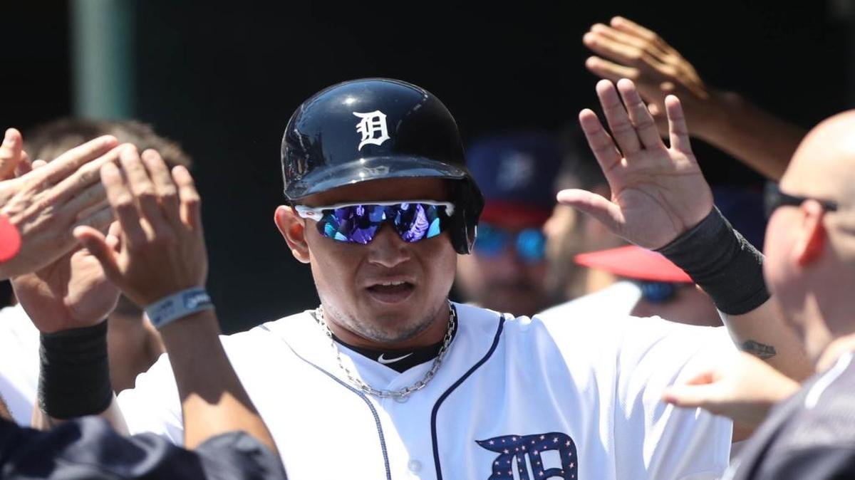 Miguel Cabrera se saluda con sus compañeros de los Tigres luego de anotar una carrera contra los Gigantes, el 4 de julio del 2017 en Comerica Park en Detroit, Mich.