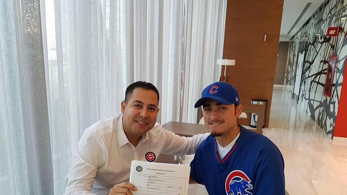 KEVIN MORENO (d) al momento de firmar su pacto de Liga Menor con los Cachorros de Chicago.