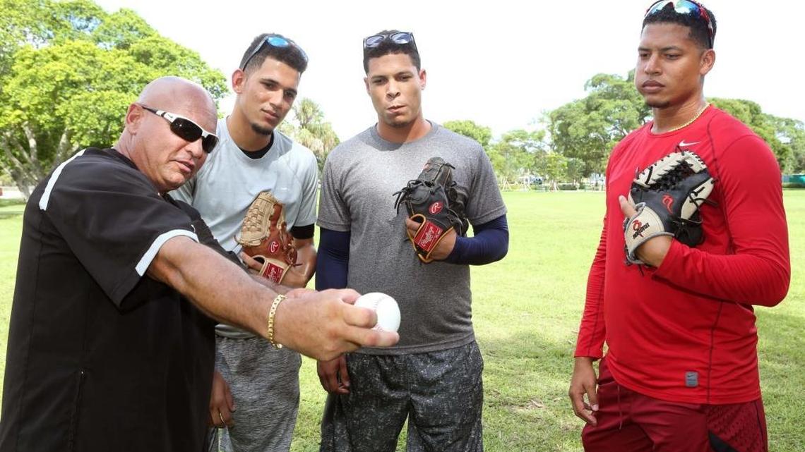 LAZARO COLLAZO (i), entrenador de pitcheo, muestra un tipo de agarre a una pelota a los peloteros cubanos (i. a d.) Jesús Adriel Balaguer, Yosibel Castillo y Michael Taylor, en Miami el martes, 16 de agosto del 2016.