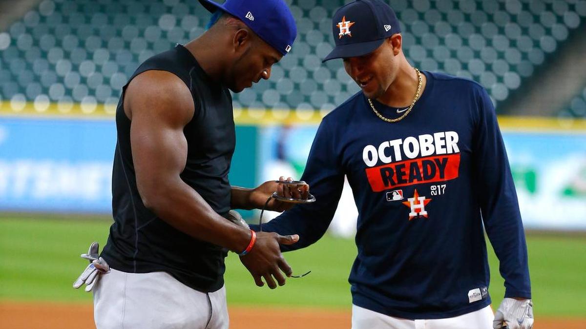 Yasiel Puig, de los Dodgers (izq.), y Yuli Gurriel, de los campeones Astros, coversan antes del Juego 3 de la Serie Mundial en Texas el pasado 27 de octubre.