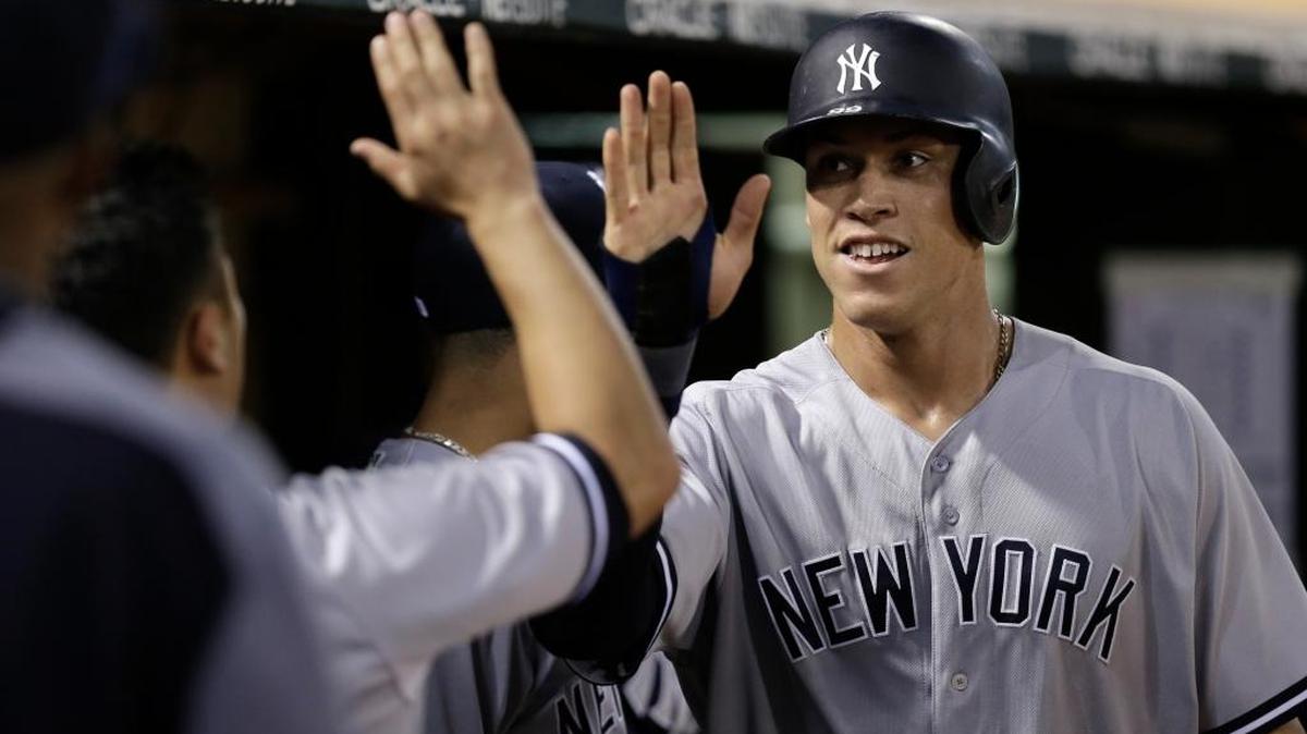 Aaron Judge (der.), de los Yankees, es felicitado por sus compañeros luego de anotar una carrera contra los Atléticos, el 16 de junio pasado, en Oakland, California. El toletero posee unos números formidables.