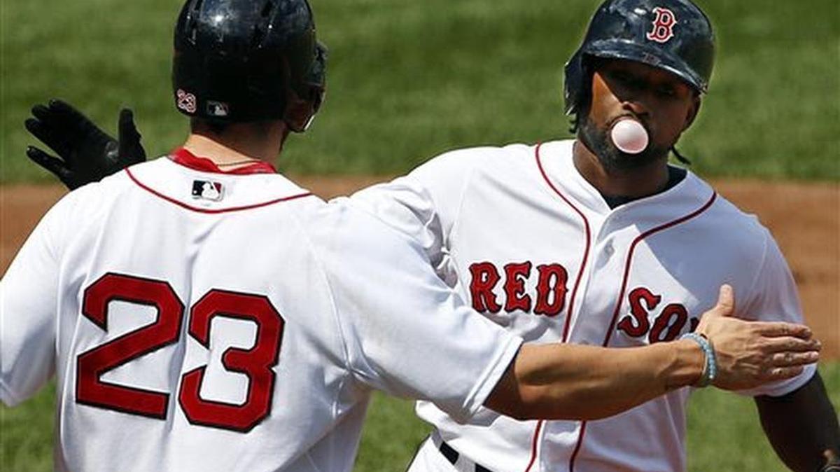 Jackie Bradley Jr. hace una bomba con su goma de mascar mientras es felicitado por Blake Swihart tras su jonrón de dos anotaciones en la segunda entrada del duelo ante los Marineros de Seattle el sábado 15 de agosto de 2015 en Boston. Bradley Jr conectó dos jonrones y tres dobletes para producir siete carreras, y los Medias Rojas de Boston le cayeron a palos a Félix Hernández para arrollar el sábado 22-10 a los Marineros de Seattle.