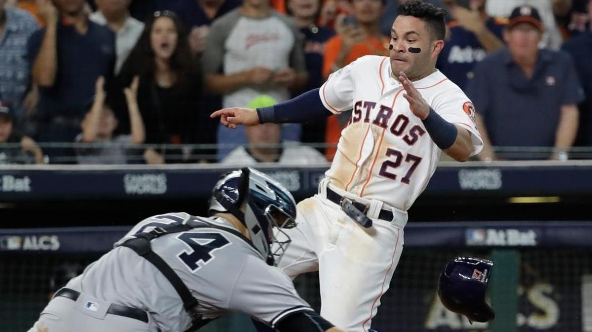 José Altuve, de los Astros, anota la carrera de la victoria en el noveno episodio al aprovechar que el receptor Gary Sánchez, de los Yankees, no puede atrapar la pelota.