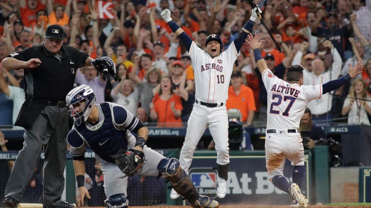 José Altuve (27) y Yuli Gurriel (10) celebran la victoria de los Astros, mientras se lamenta Gary Sánchez, el sábado.
