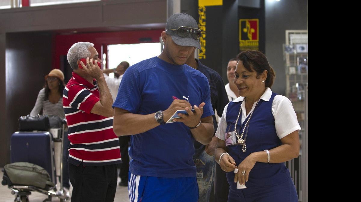 
Yulieski Gourriel firma un autógrafo a una trabajadora del Aeropuerto Internacional José Martí en La Habana, el 29 de mayo del 2014.
