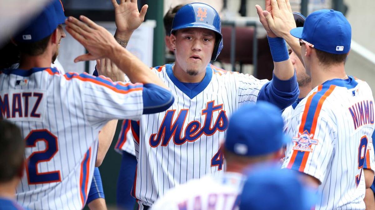 EL VENEZOLANO Wilmer Flores (centro) saluda a sus compañeros de equipo en el partido donde pegó seis imparables en la victoria de los Mets sobre los Cachorros de Chicago, el domingo en Nueva York.