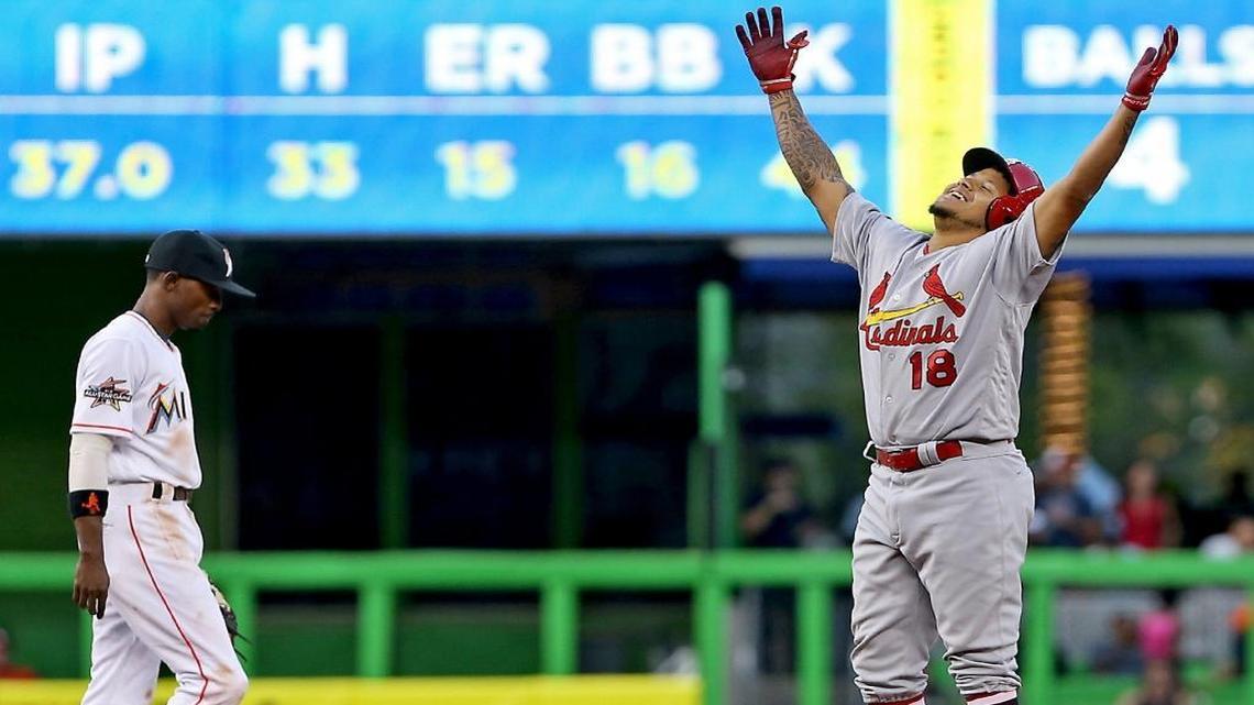 Carlos Martínez, de los Cardenales, celebra su doble de tras carreras, mientras Dee Gordon, de los Marlins, muestra la actitud del desconsuelo, la noche del lunes 8 de mayo del 2017 en Miami.
