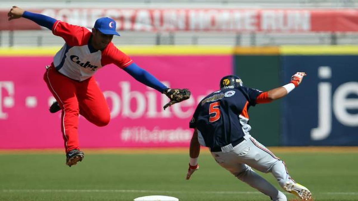 El jugador de Venezuela  Orlando Arcia (der.) llega quieto a segunda base ante el esfuerzo del el torpedero del equipo cubano Luis Alberto Valdez, el jueves 5 de febrero.