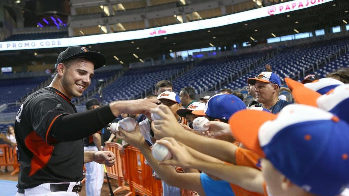 JOSÉ FERNÁNDEZ firma pelotas antes del comienzo de un choque contra los Nacionales el 20 de mayo en Miami.