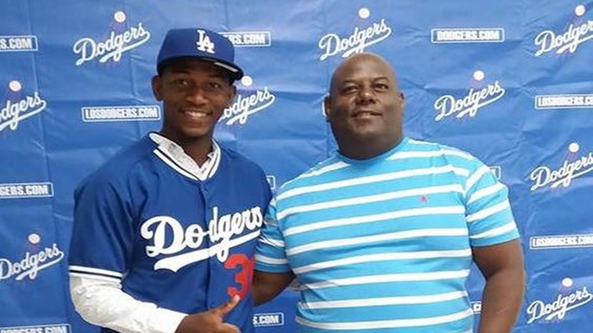 JULIO ENRIQUE Romero junto a su padre. Firma pacto con los Dodgers.