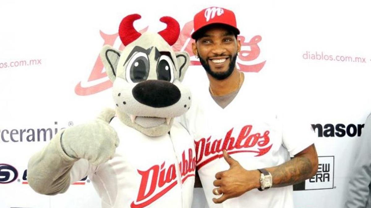 Alexei Ramírez posa con la mascota de los Diablos Rojos.