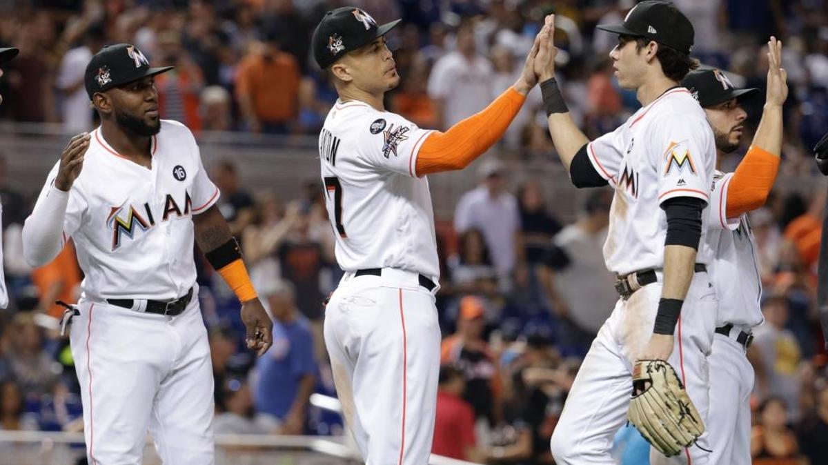 MARCELL OZUNA, Giancarlo Stanton (c) y Christian Yelich (d) se saludan tras un triunfo de los Marlins sobre Atlanta el 30 de septiembre.