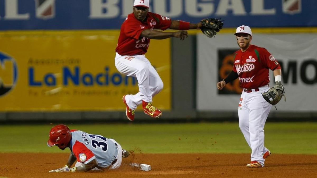 José Adolis García, de Ciego de Avila, trata de alcanzar la base pero Yuniesky Betancourt, de los Venados de Mazatlán, lo pone out en el estadio de Quisqueya, en Santo Domingo, el sábado 6 de febrero del 2016.