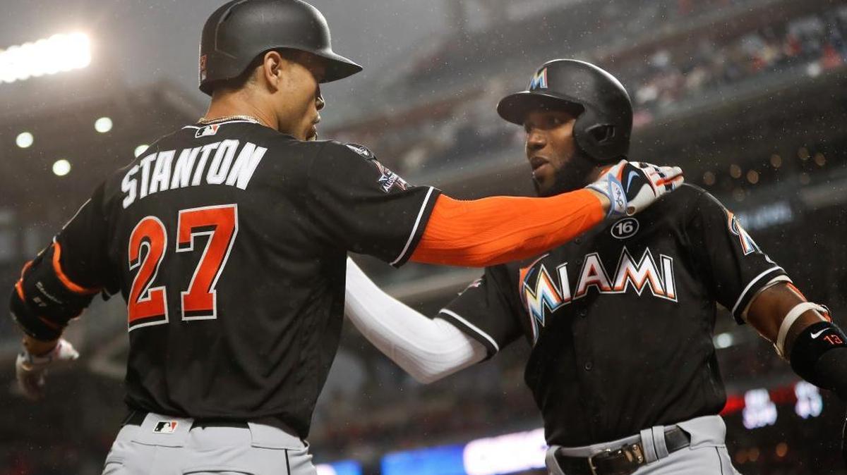 GIANCARLO STANTON (27) saluda a Marcell Ozuna tras pegar un cuadrangular contra los Nacionales el 29 de agosto.
