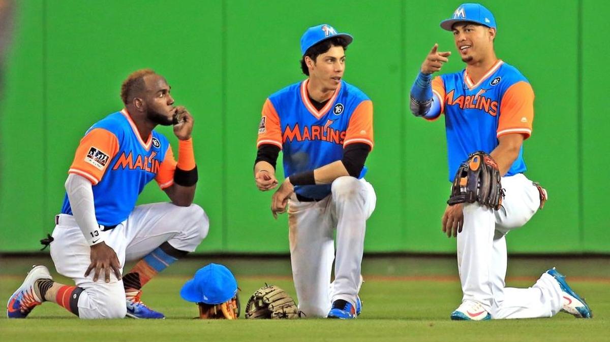 EL TRIO de jardineros de Miami Marcell Ozuna (13), Christian Yelich (21) y Giancarlo Stanton (27), durante una pausa de un juego contra San Diego el 25 de agosto del 2017.