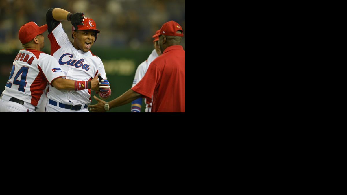 
El pelotero cubano Yasmani Tomas (centro) es felicitado por Frederich Cepeda (izq.) tras pegar un jonrón de tres carreras contra Taiwán, durante un partido del Clásico Mundial de Béisbol el 9 de marzo del 2013 en Tokio, Japón.


