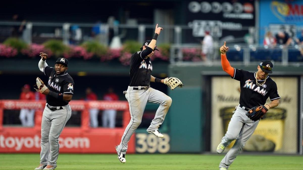 Marcell Ozuna, Christian Yelich y Giancarlo Stanton (de izq. a der.) celebran el triunfo de los Marlins en el primer partido de la doble jornada ante Filadelfia, el 22 de agosto del 2017 en Filadelfia.