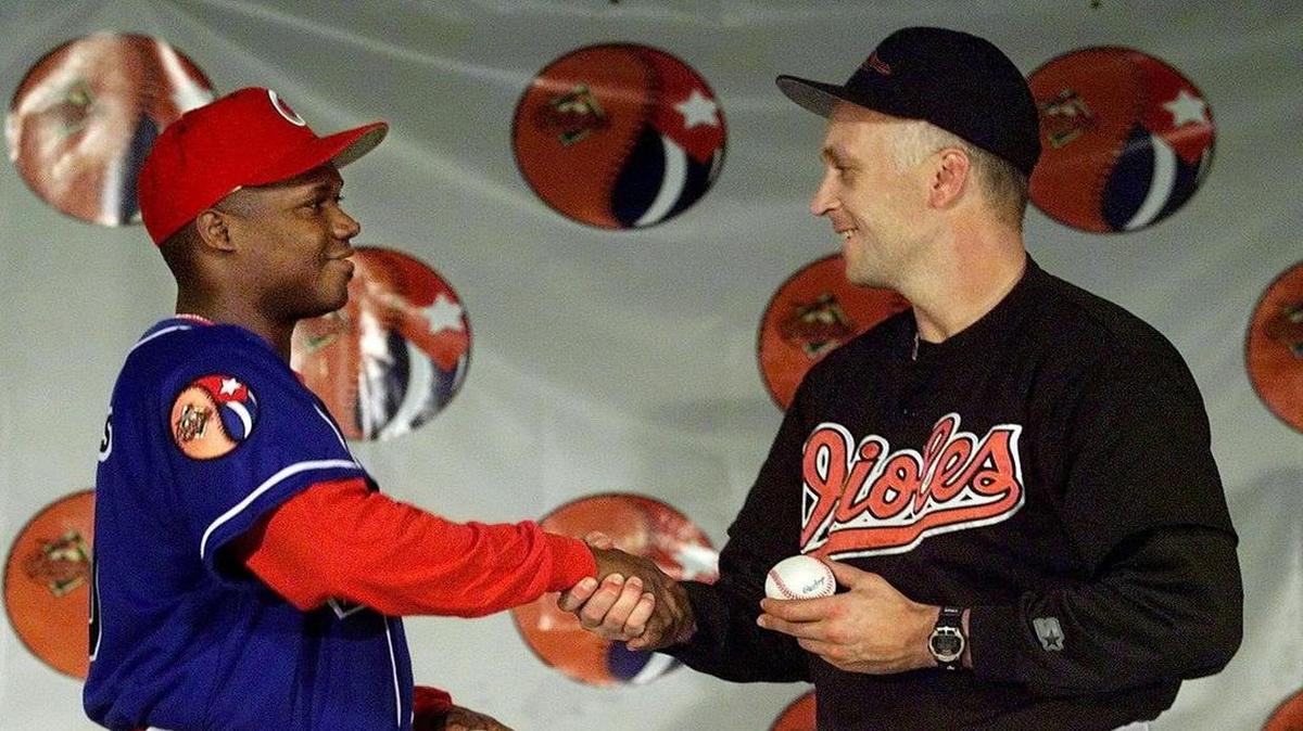 
El jugador de la selección cubana Omar Linares (izq.) y Cal Ripken Jr., de los Orioles, intercambian pelotas autografiadas en el partido efectuado entre ambos equipos el 3 de mayo de 1999 en el estadio Camden Yards, en Baltimore.
