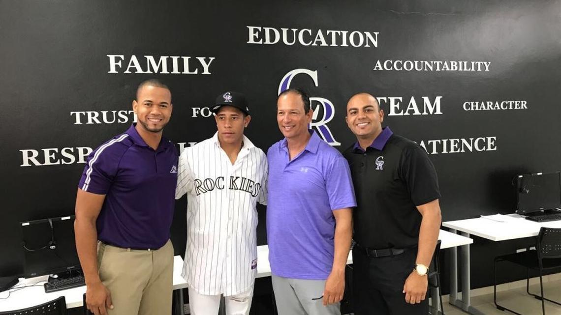 EDDY DIAZ (segundo izq.) junto a ejecutivos de los Rockies al firmar su pacto profesional.