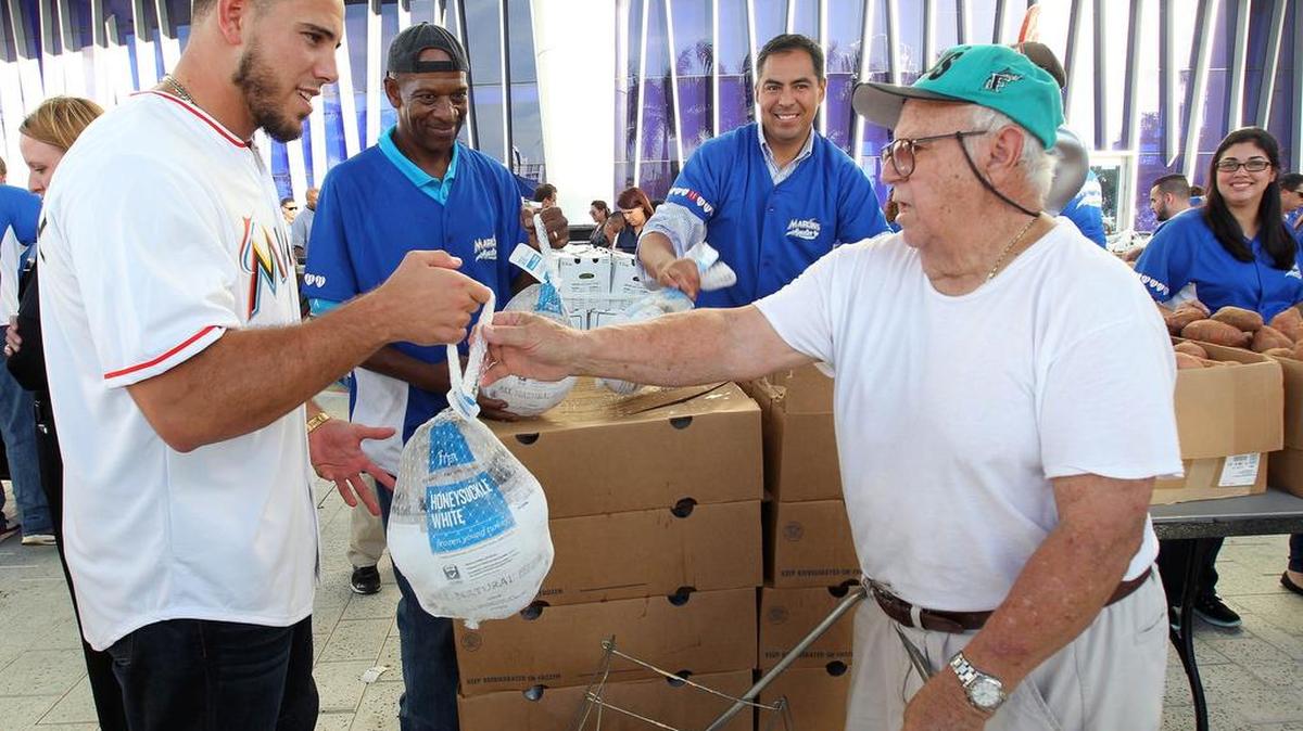 JOSE FERNANDEZ le entrega un pavo a Lorenzo Crespo residente de la Pequeña Habana, durante la entrega de pavos por la organización de los Marlins a cientos de personas de bajos ingresos el viernes 20 de noviembre.