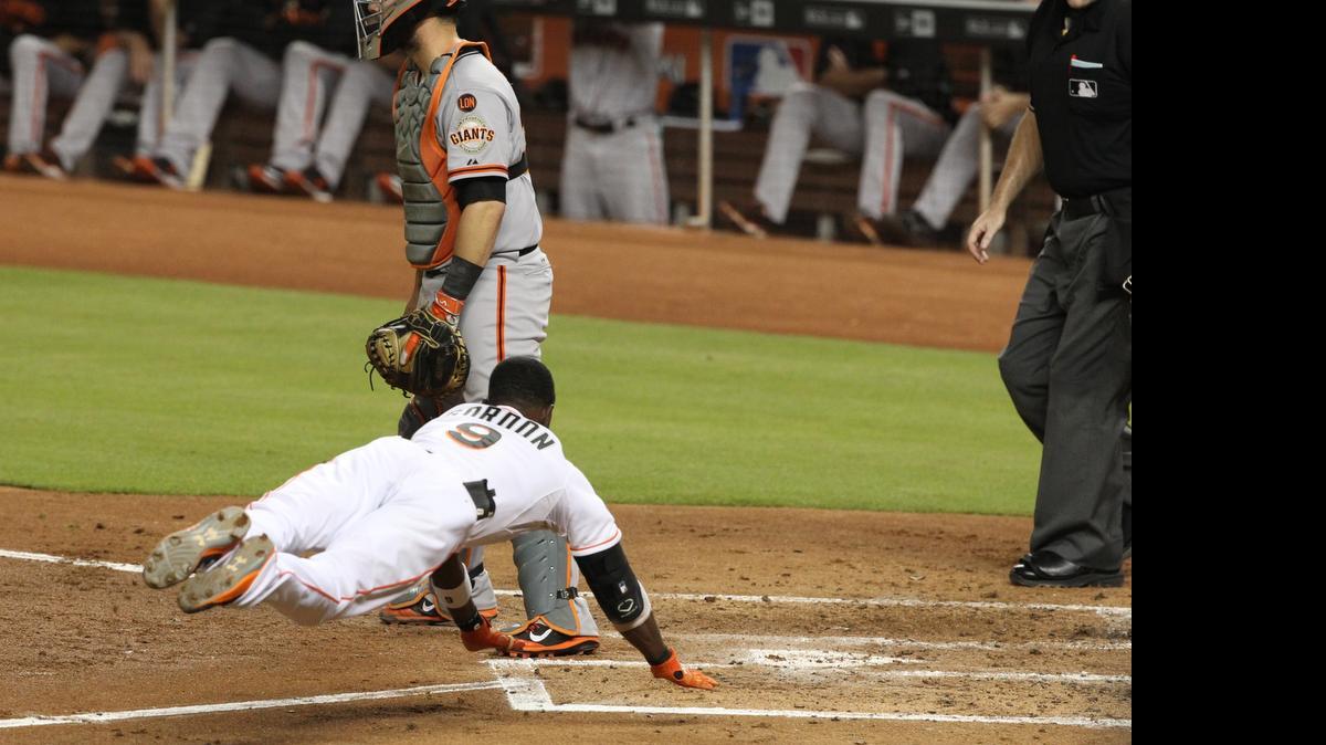 
El camarero Dee Gordon se desliza en el plato para completar un cuadrangular dentro del terreno en el triunfo 5-3 ante los Gigantes, el martes 30 de junio en Miami.
