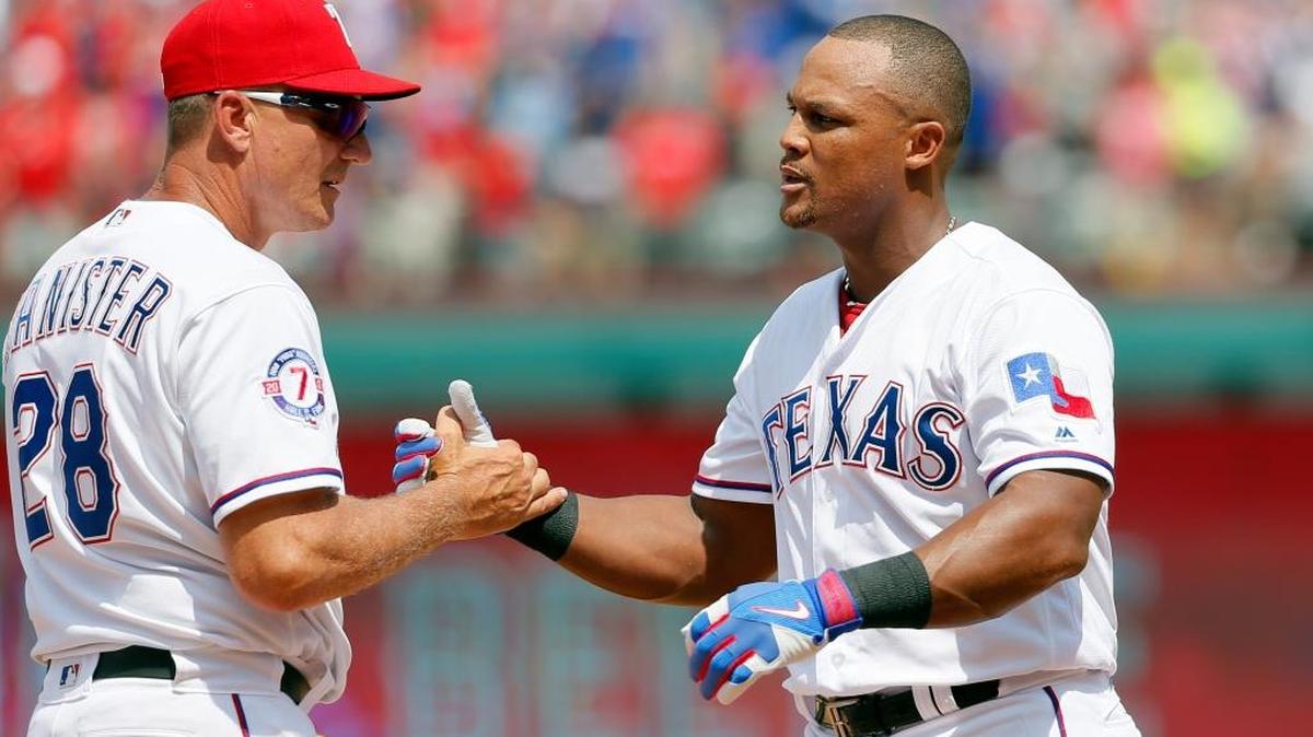 El mánager de los Rangers Jeff Banister (izq.) felicita a Adrián Beltré, quien conectó un doble al lanzador de los Orioles Wade Miley en el cuarto inning, el domingo 30 de julio del 2017, en Arlington, Texas, para sumar el hit 3,000 de su carrera.