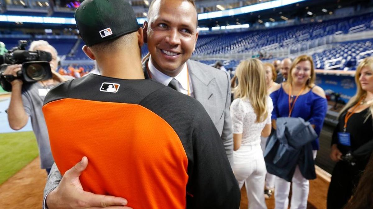 JOE DUNAND es abrazado por su tío Alex Rodríguez en el Marlins Park el 23 de junio.