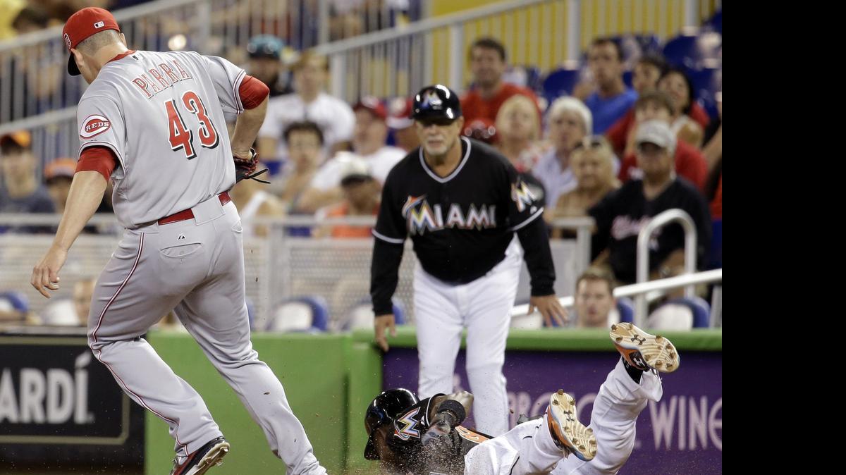 
Dee Gordon, de los Marlins, llega quieto a la base pero se lesiona contra los Rojos, el sábado.
