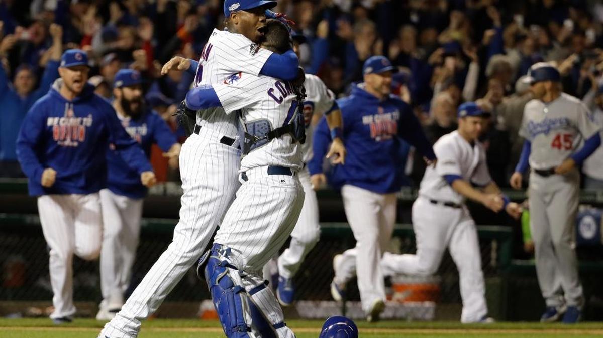 El venezolano Willson Contreras (der.) se funde en un abrazo con el cubano Aroldis Chapman (54), de los Cachorros, luego de forzar a Yasiel Puig a batear para double play y asegurar la victoria sobre los Dodgers, la noche del sábado 22 de octubre del 2016, en Chicago.