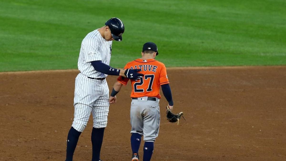 JOSÉ ALTUVE (der.) y Aaron Judge se saludan en la segunda base tras un doble del jardinero de los Yankees en Nueva York el 18 de octubre del 2017.