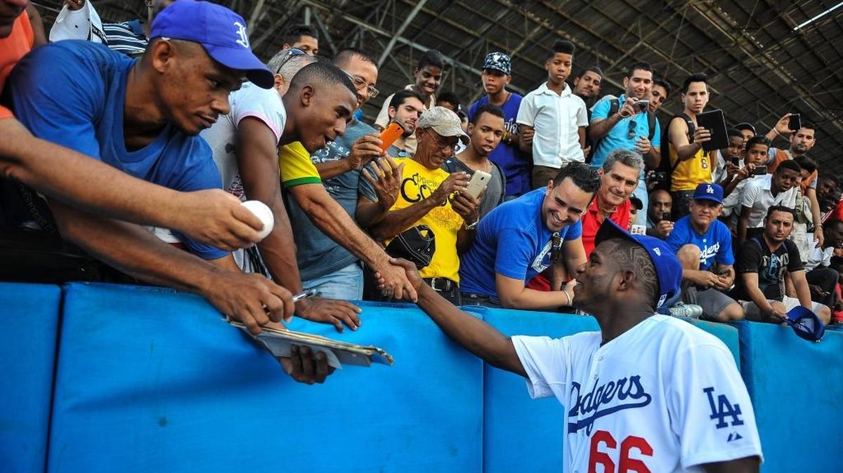 Cuban MLB player Yasiel Puig (R) shakes hands with fans at the Latin American Stadium in Havana, on December 16, 2015.