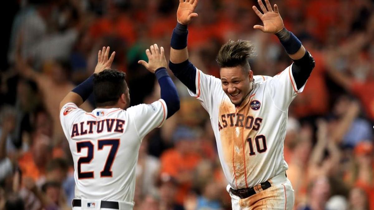 YULI GURRIEL es felicitado por José Altuve al anotar una carrera contra los Yankees el 21 de octubre.